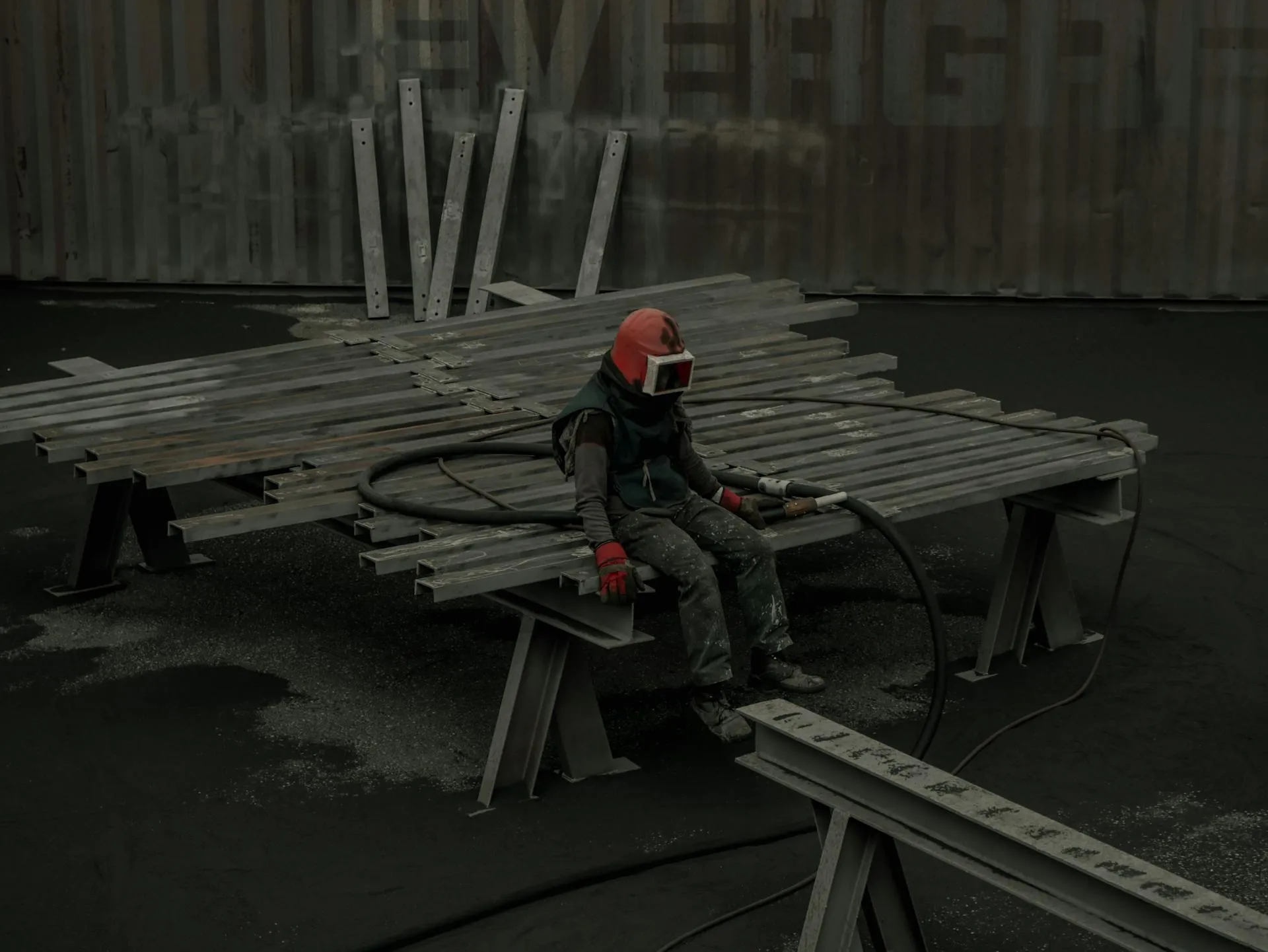 Travailleur du bâtiment en casque et tenue de protection, assis sur un banc de chantier